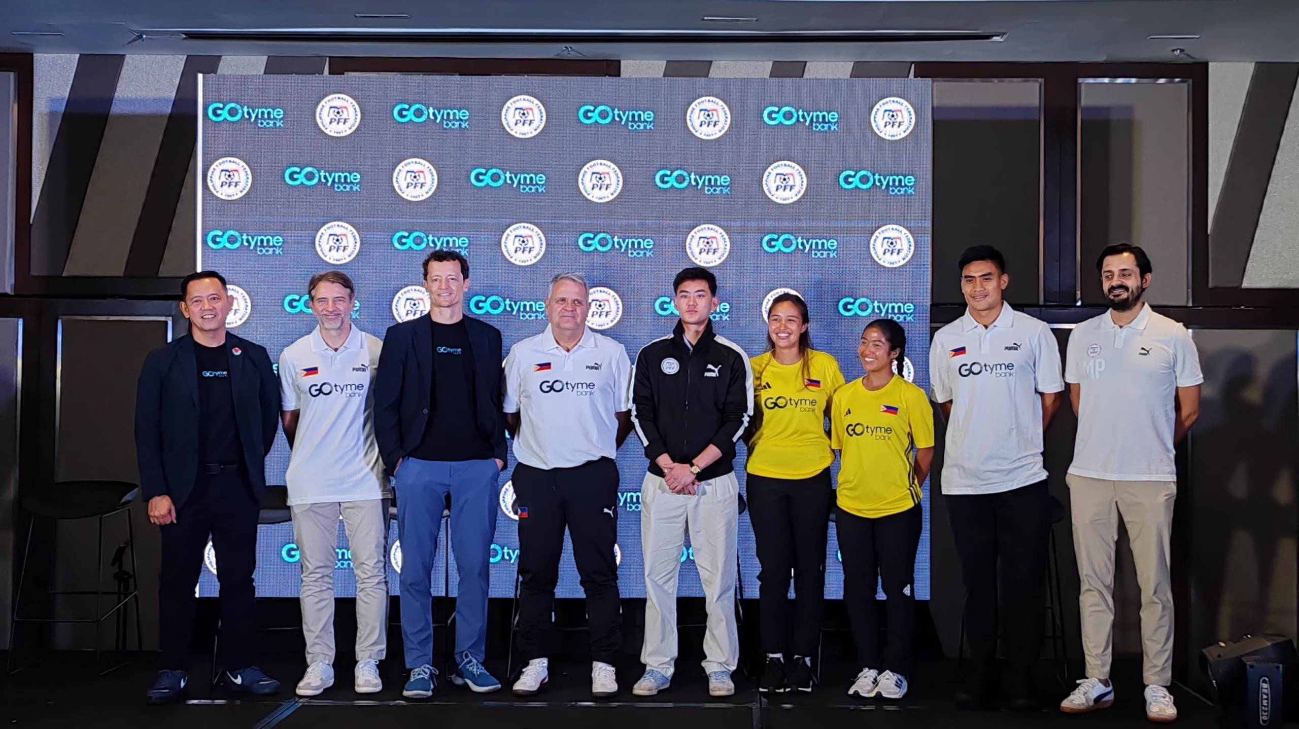 Group photo of Philippine Football Federation officials, athletes, and GOtyme Bank executives during a partnership event, with branding logos displayed prominently in the background.