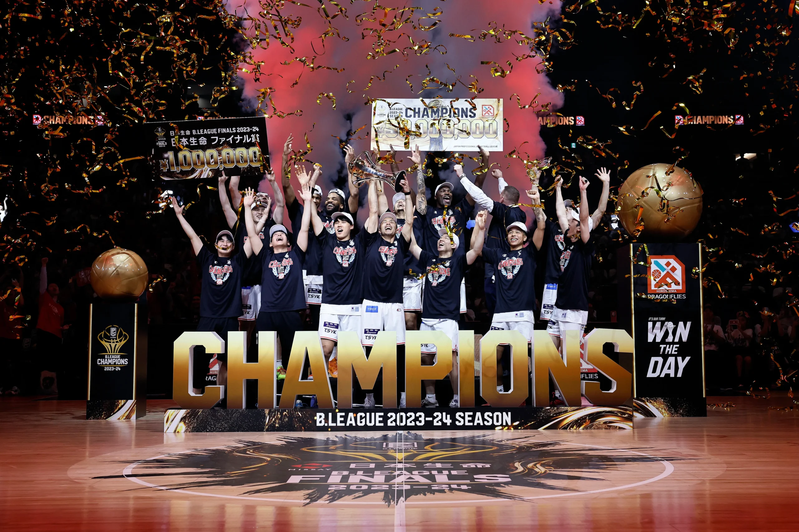 Basketball team celebrating their championship victory at the EASL 2024–25 Season Finals in Macau, with confetti falling and a CHAMPIONS banner on stage.