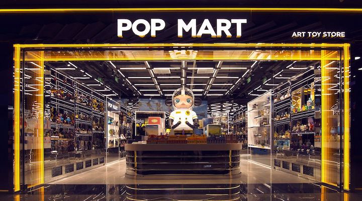 POP MART art toy store with illuminated entrance and collectible figures on display.