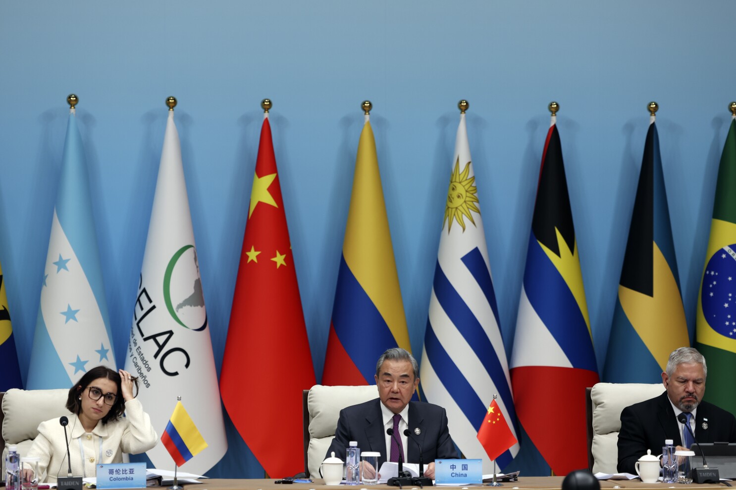 Delegates from China and Latin American countries attending an international summit, seated in front of national flags including China, Colombia, Uruguay, and others during a CELAC-China meeting.