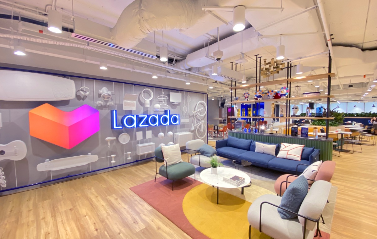 Modern Lazada office interior in Singapore featuring vibrant lounge area, company branding, and creative open workspace design.