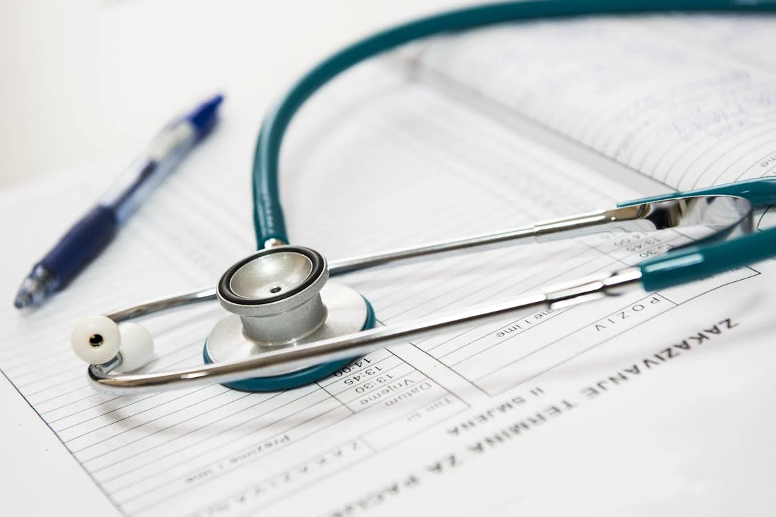 Close-up of a stethoscope and pen placed on a medical chart, symbolizing healthcare, diagnostics, and patient record management.